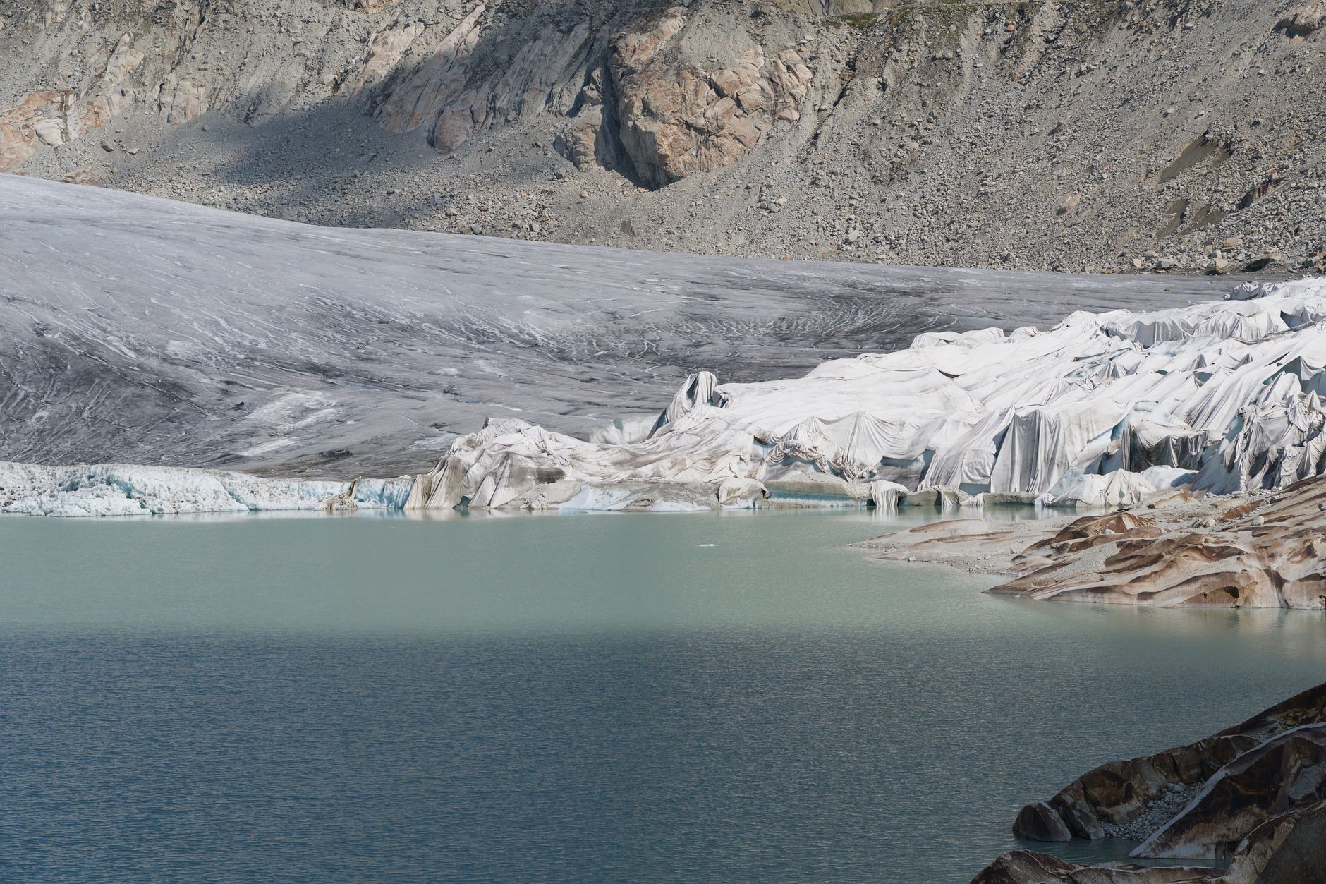 Remote mountain cabin near turquoise glacier water